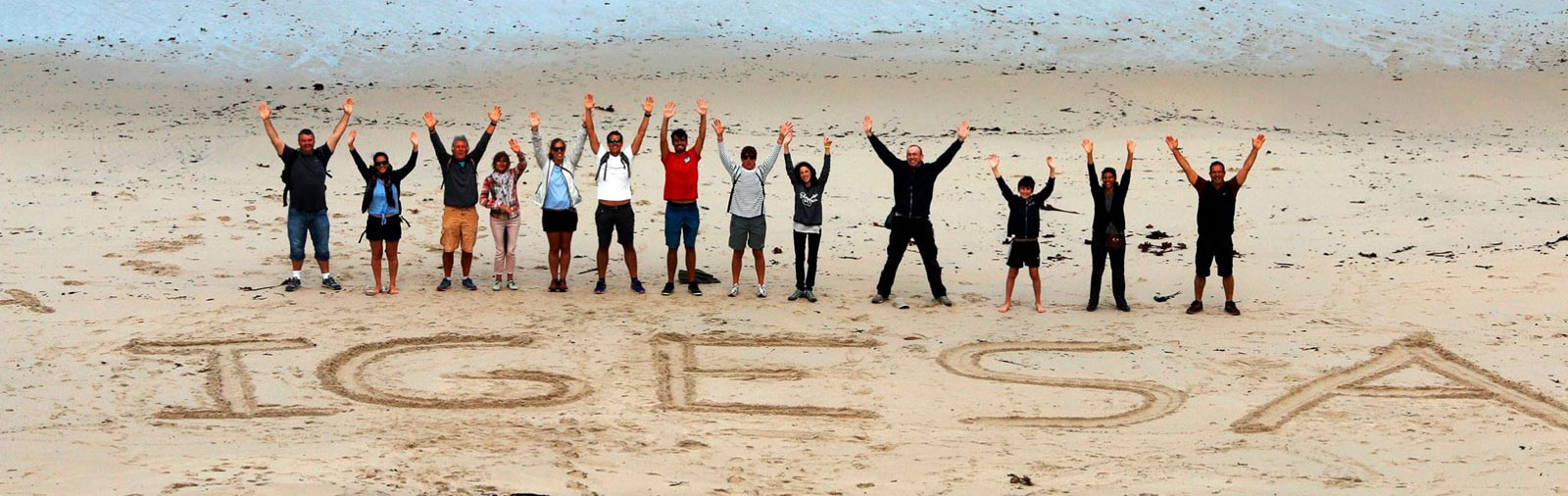 Inscription IGESA sur une plage avec un groupe de vacanciers